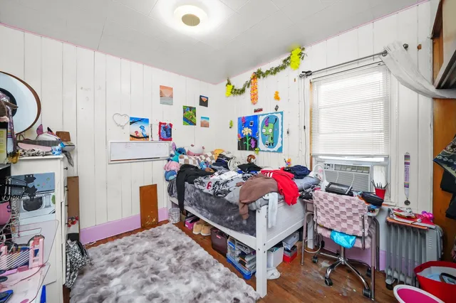 a bedroom with furniture a baby crib and a window