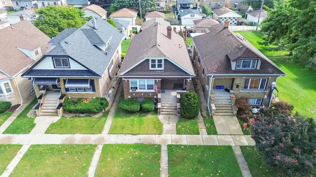 a aerial view of a brick house next to a yard