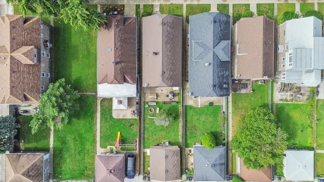 an aerial view of multiple house with a yard and outdoor seating