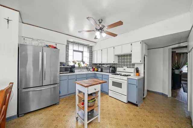 a kitchen with stainless steel appliances white cabinets and a refrigerator