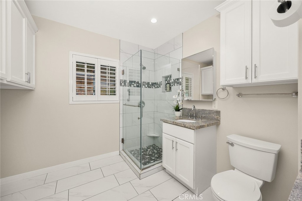 378 Patterson Drive Monrovia, CA 91016 - Photo 22 of 42 a bathroom with a granite countertop sink a toilet and cabinets