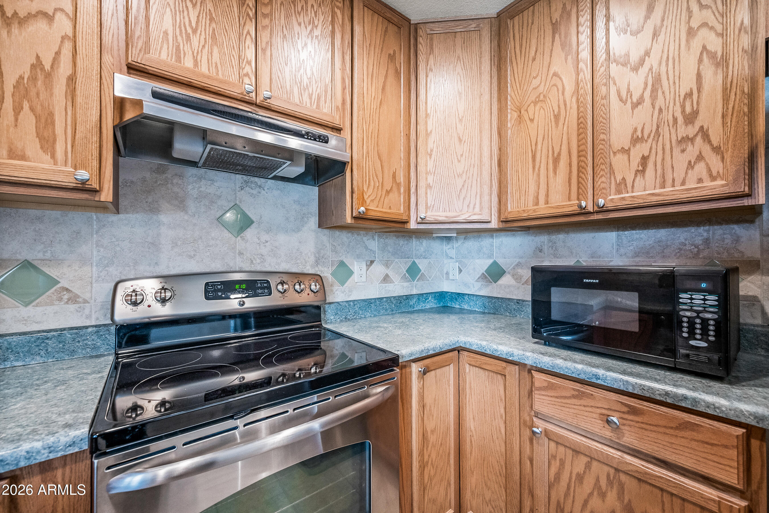 1108 West Mission Lane Phoenix, AZ 85021 - Photo 8 of 30 a kitchen with wooden cabinets and a stove top oven