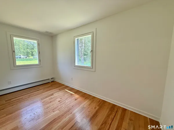 a view of a room with wooden floor and windows