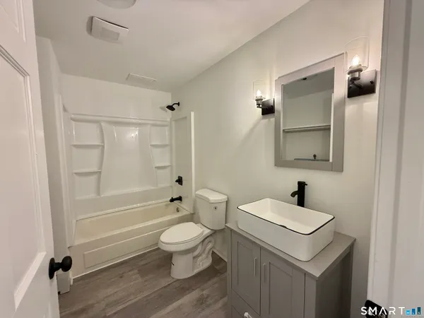 a bathroom with a sink a toilet and shower