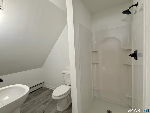a white toilet sitting next to a bath tub