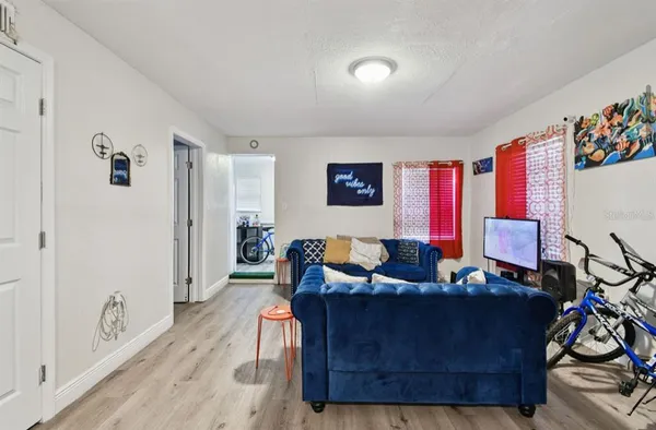 a living room with furniture and a wooden floor