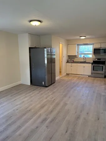 a kitchen with stainless steel appliances kitchen island granite countertop a refrigerator and a stove top oven