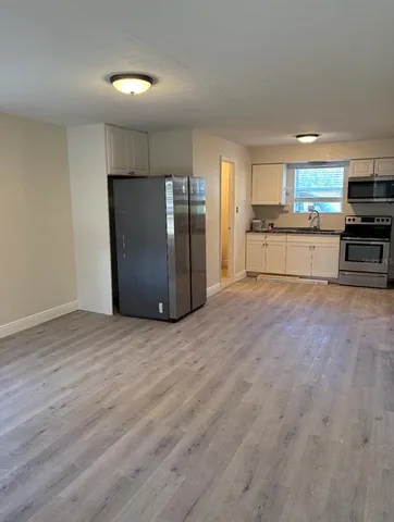 a kitchen with stainless steel appliances kitchen island granite countertop a refrigerator and a stove top oven