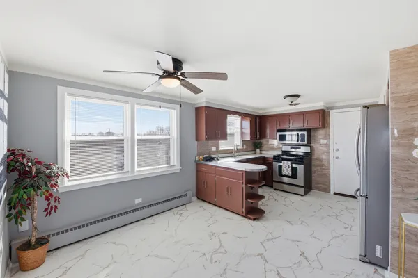 a kitchen with refrigerator a oven and chairs