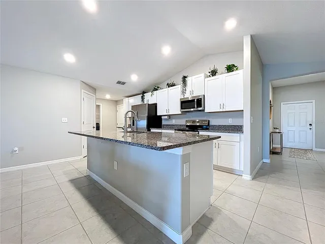 a kitchen with stainless steel appliances granite countertop a sink stove and microwave