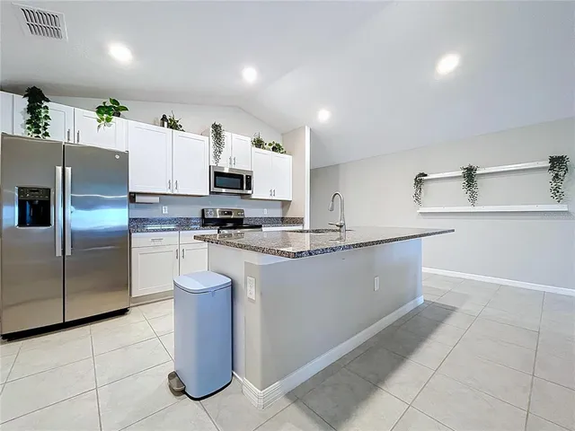 a kitchen with granite countertop a sink a stove and microwave