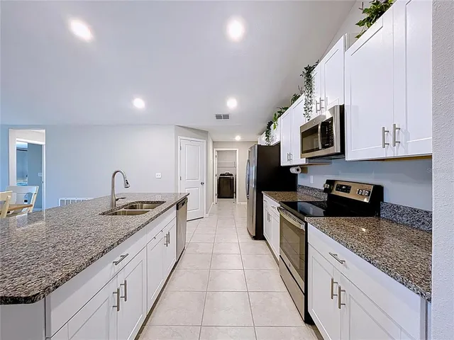 a kitchen with granite countertop a sink and cabinets
