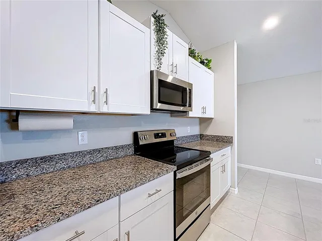 a kitchen with a granite countertop cabinets and refrigerator