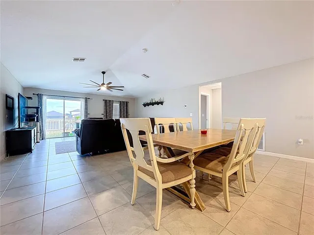 a living room with furniture a ceiling fan and a window