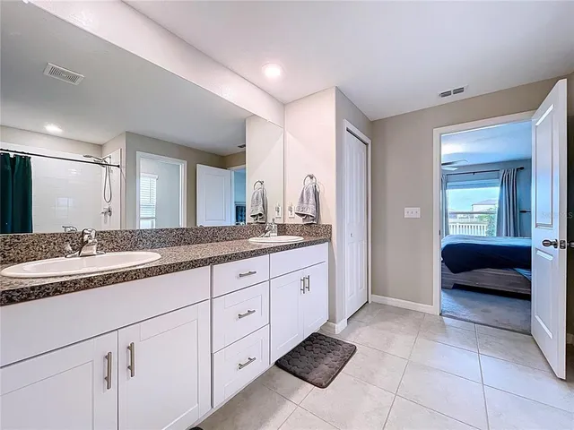 a bathroom with a granite countertop sink and a mirror
