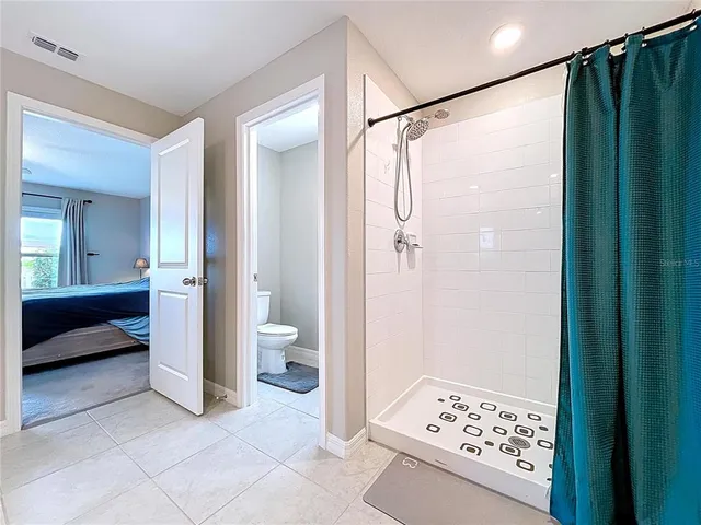 a bed room with a bed and a ceiling fan