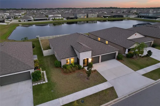 an aerial view of house with yard and lake view
