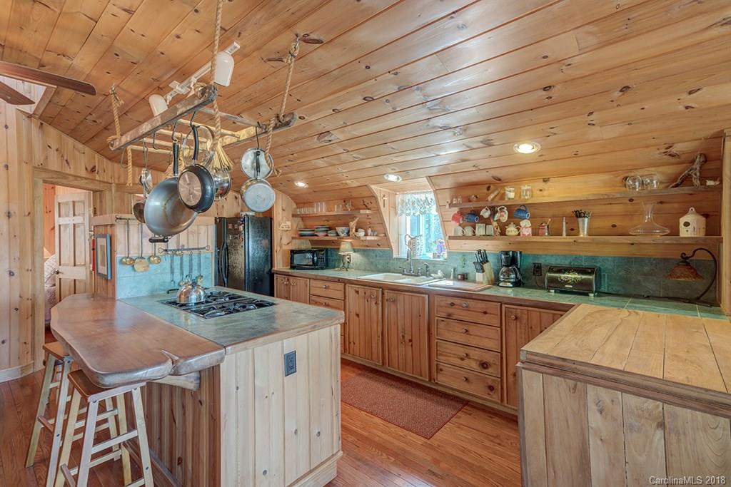 731 Phillips Dairy Road Tryon, NC 28782 - Photo 22 of 36 a kitchen that has a kitchen island wooden cabinets and stainless steel appliances