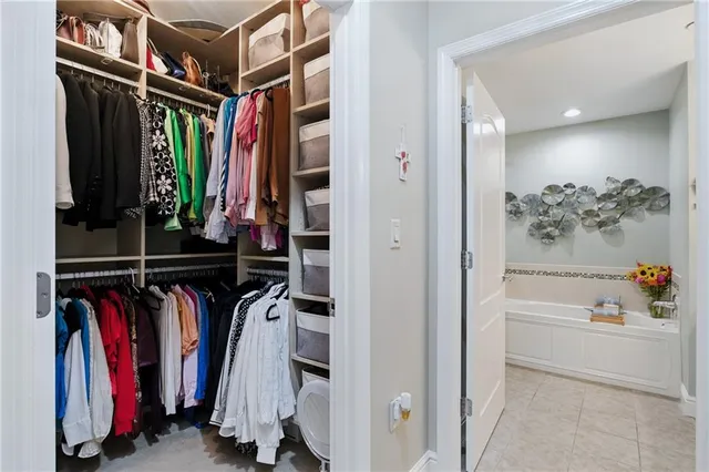 a view of walk in closet with clothes and shoes