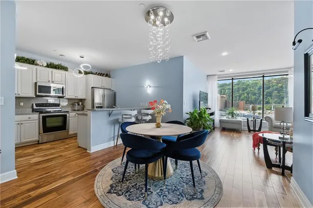a view of a dining room with furniture a chandelier and wooden floor