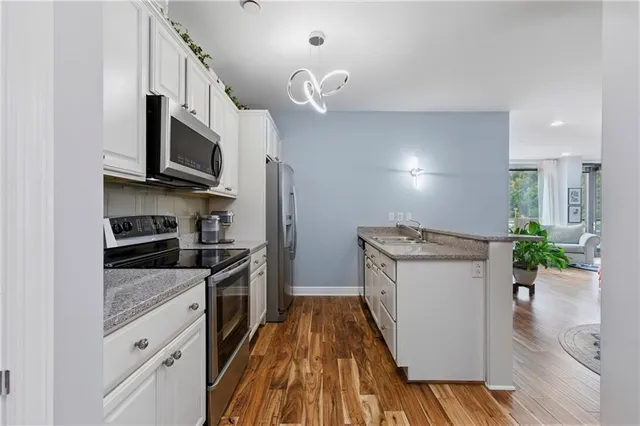 a kitchen with stainless steel appliances granite countertop a stove a sink and a refrigerator
