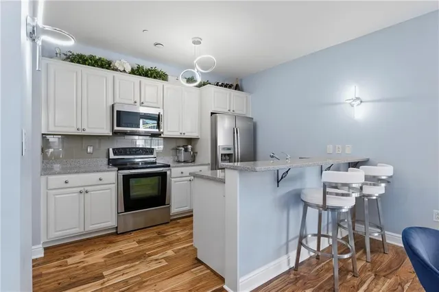 a kitchen with stainless steel appliances a stove refrigerator sink and microwave