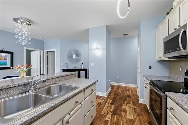 a kitchen with granite countertop a sink stainless steel appliances a counter space and cabinets
