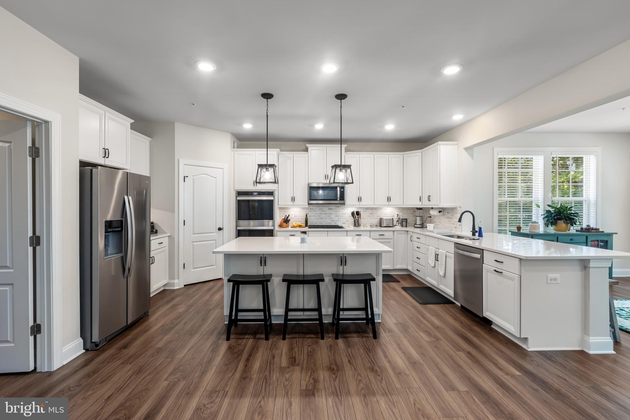 9909 Kildore Way Fort Washington, MD 20744 - Photo 11 of 43 a kitchen with stainless steel appliances a dining table chairs microwave and cabinets