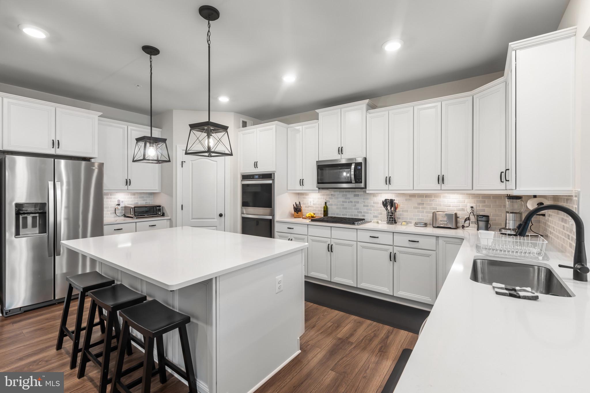 9909 Kildore Way Fort Washington, MD 20744 - Photo 13 of 43 a kitchen with kitchen island a white counter top space stainless steel appliances and cabinets