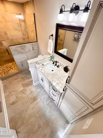 an empty room with a chandelier fan and wooden floor