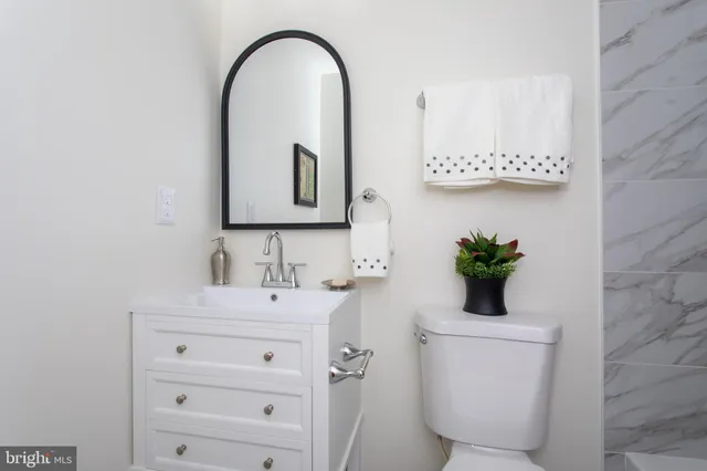 a bathroom with a toilet sink and mirror