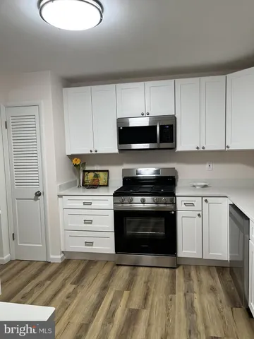 a kitchen with granite countertop a stove and a microwave