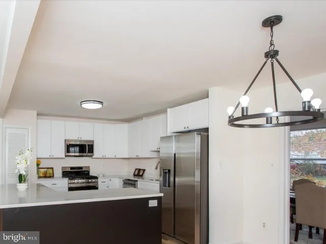 a kitchen with stainless steel appliances a sink a stove a refrigerator and cabinets