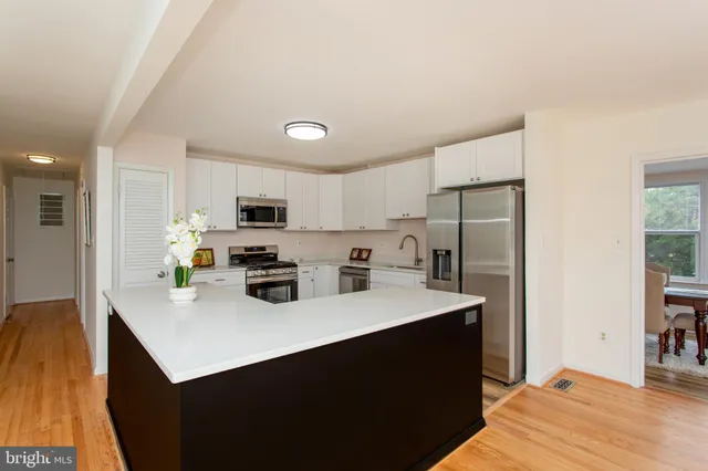 a kitchen with stainless steel appliances a sink stove refrigerator and cabinets