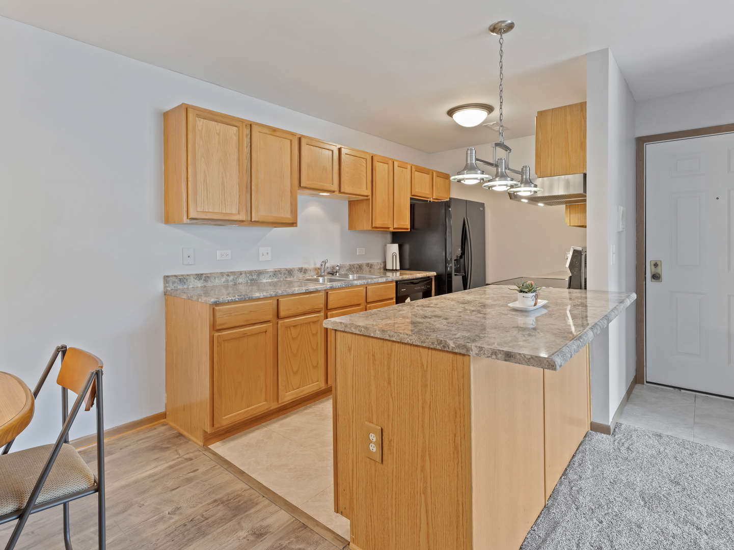 935 Golf Course Road, Unit 7 Crystal Lake, IL 60014 - Photo 8 of 21 a kitchen with a sink a refrigerator and cabinets