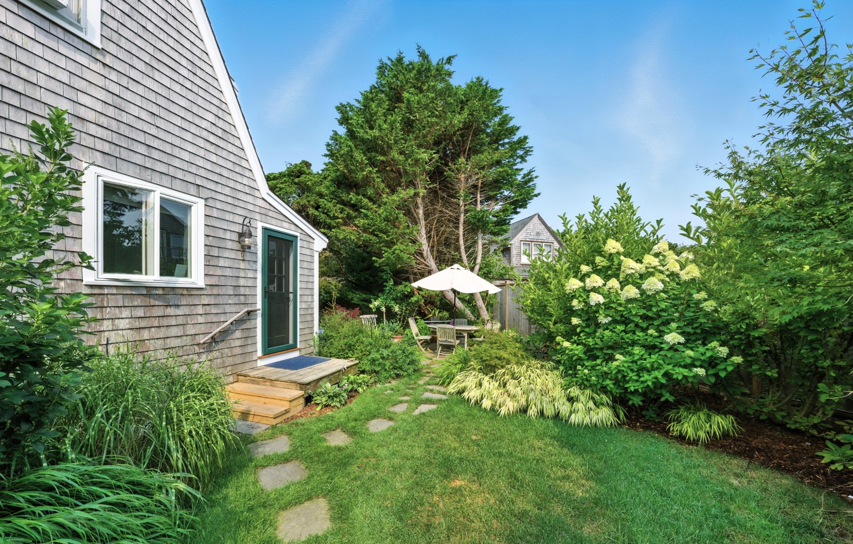 1 Halyard Lane Nantucket, MA 02554 - Photo 12 of 59 a backyard of a house with table and chairs and potted plants
