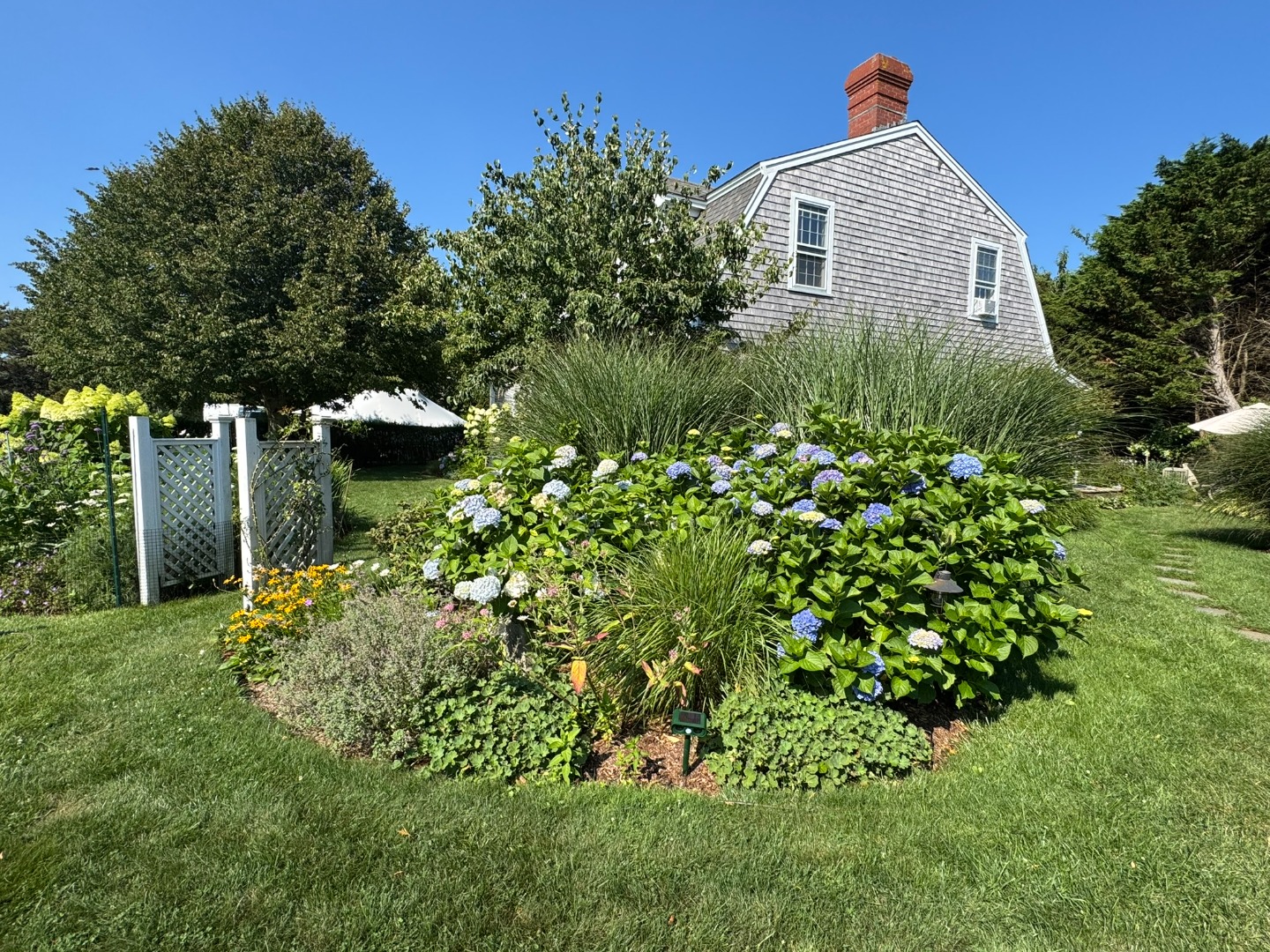 1 Halyard Lane Nantucket, MA 02554 - Photo 57 of 59 a view of a back yard with plants and large trees