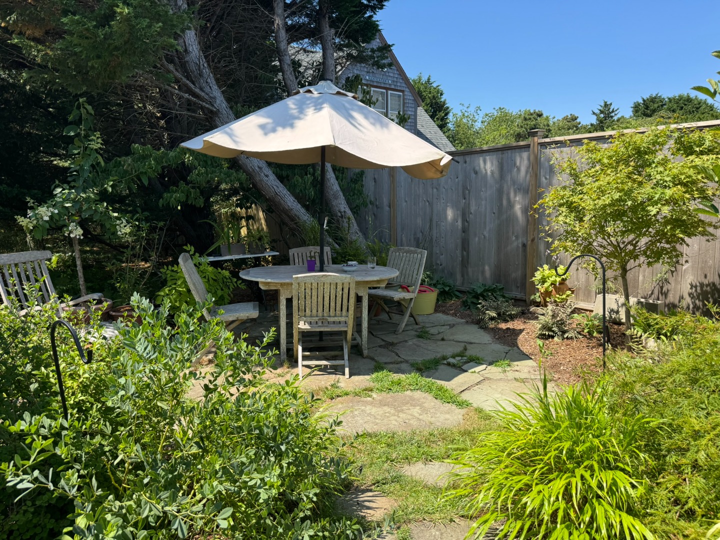 1 Halyard Lane Nantucket, MA 02554 - Photo 8 of 59 a view of a chair and table in backyard with plants
