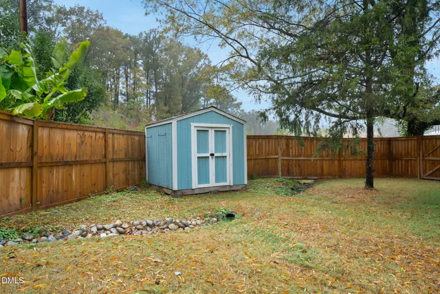 a view of a house with a barbeque and wooden stairs