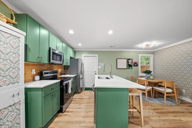 a kitchen with stainless steel appliances kitchen island granite countertop a sink and cabinets