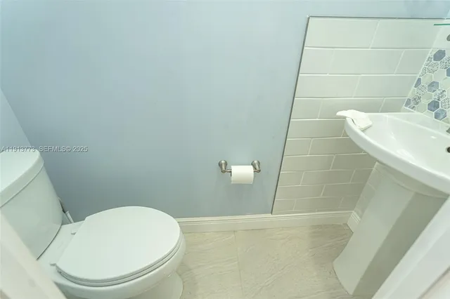 a white toilet sitting next to a white sink