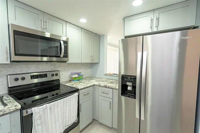 a kitchen with stainless steel appliances a refrigerator sink and microwave