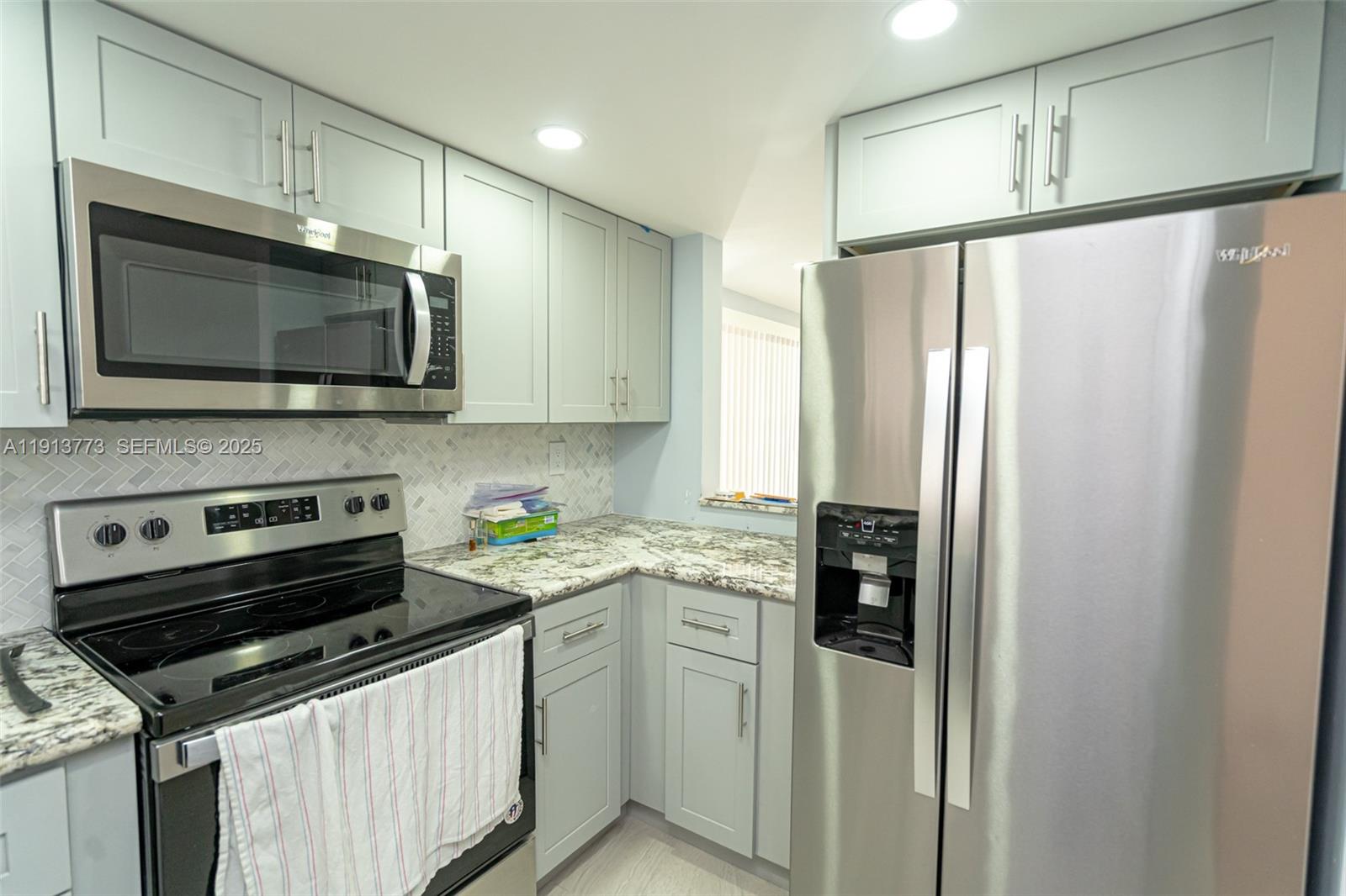 1070 West 43rd Place, Unit 38 Hialeah, FL 33012 - Photo 12 of 25 a kitchen with stainless steel appliances a refrigerator sink and microwave