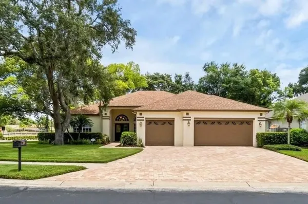 a front view of a house with a garden and trees