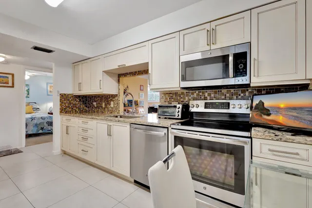 a kitchen with cabinets stainless steel appliances and a sink