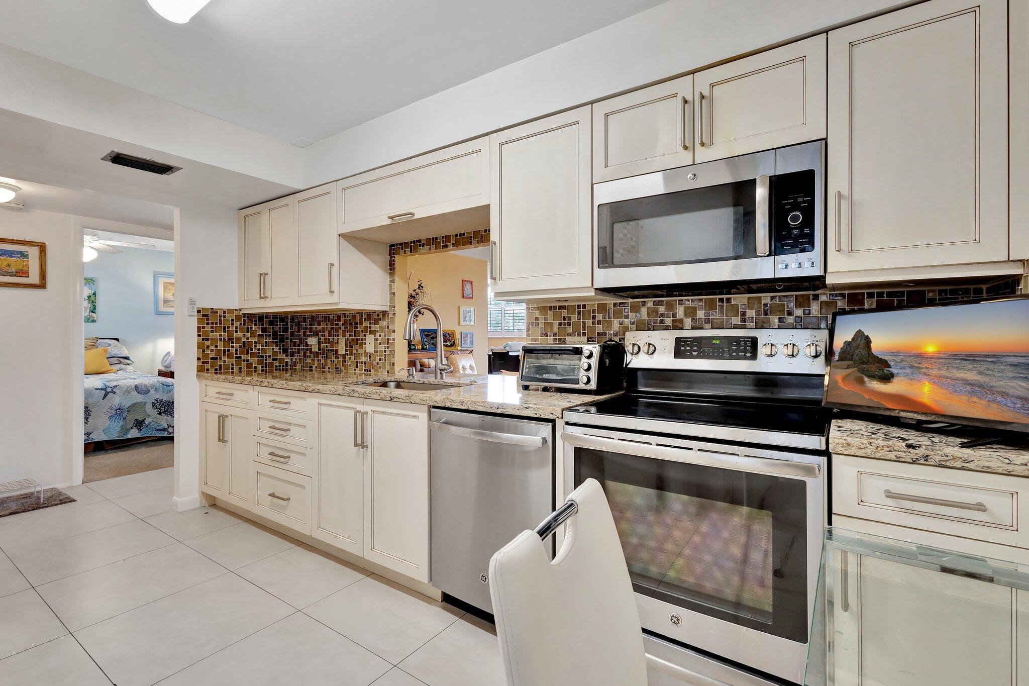 6461 Northwest 2nd Avenue, Unit 512 Boca Raton, FL 33487 - Photo 2 of 22 a kitchen with cabinets stainless steel appliances and a sink