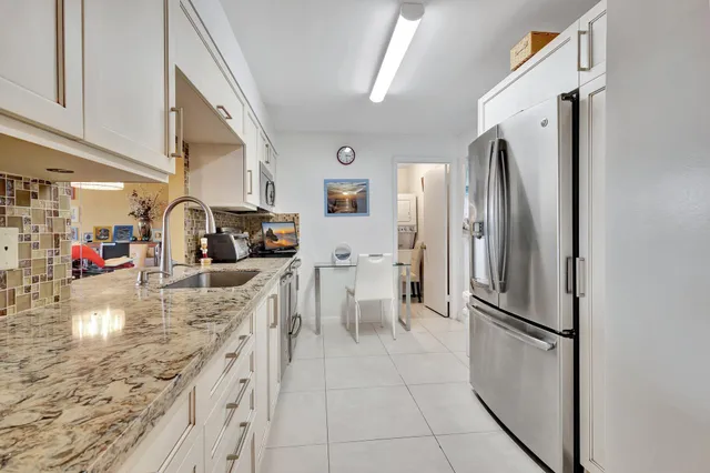 a kitchen with stainless steel appliances granite countertop a refrigerator and a sink