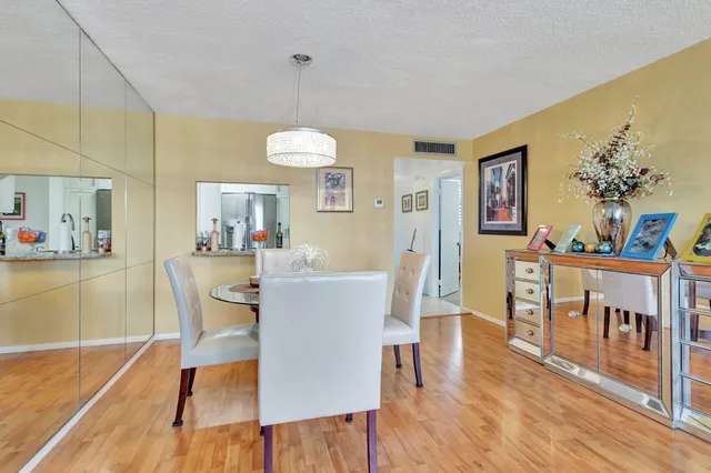 a view of a dining room with furniture a chandelier and wooden floor