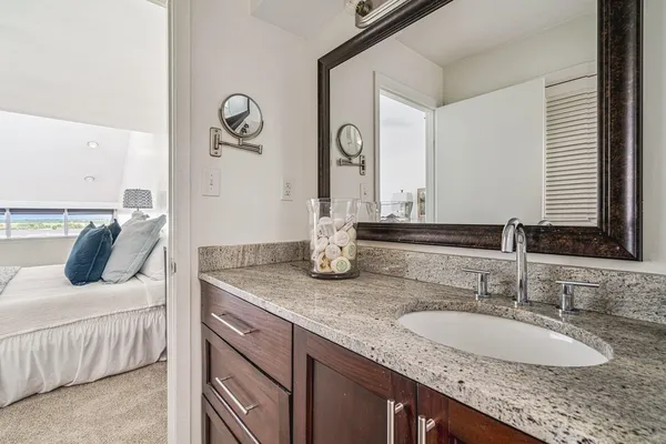 a bathroom with a granite countertop sink and a mirror