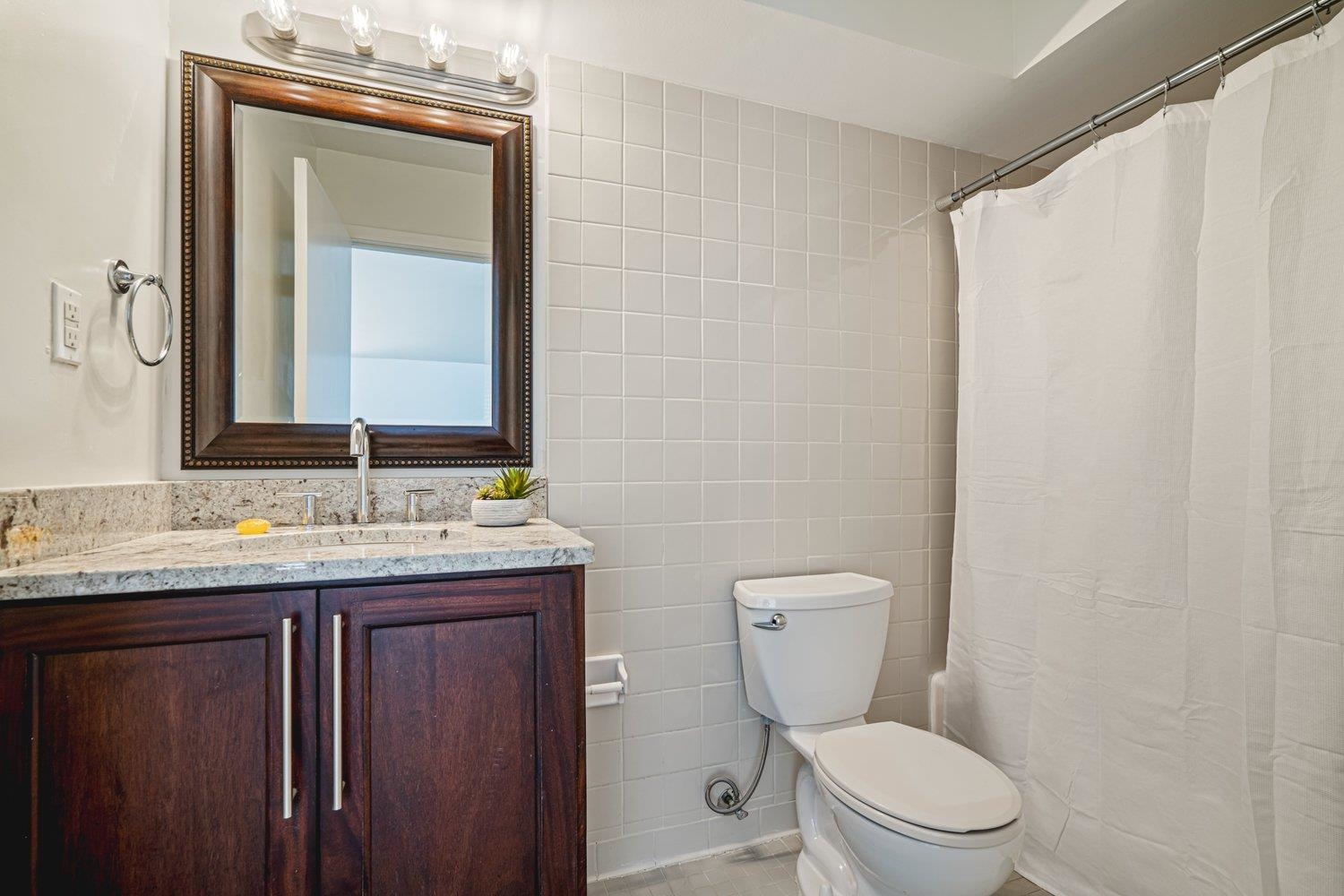 335 Riverbluff Place, Unit 3 Memphis, TN 38103 - Photo 15 of 17 a bathroom with a granite countertop toilet sink and mirror